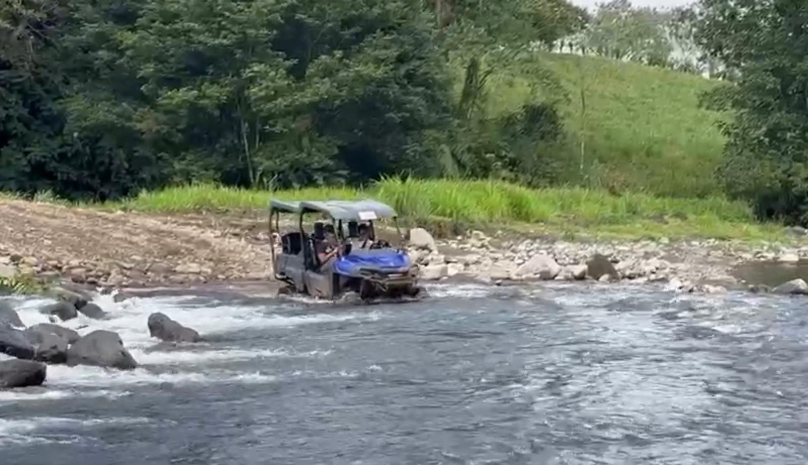 UTV crossing a river in Costa Rica rainforest